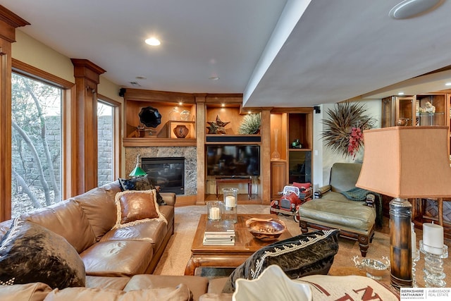 living room featuring built in shelves, recessed lighting, and a premium fireplace