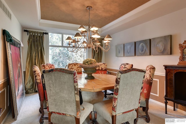 carpeted dining room with a chandelier, visible vents, crown molding, and a raised ceiling