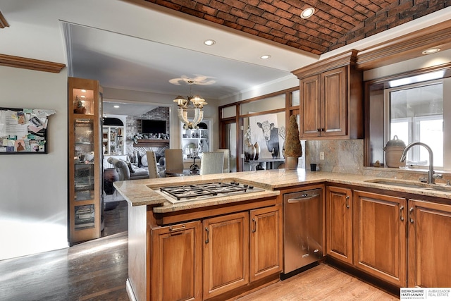 kitchen featuring brick ceiling, brown cabinets, and a sink