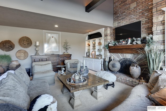 living area with beamed ceiling and a brick fireplace