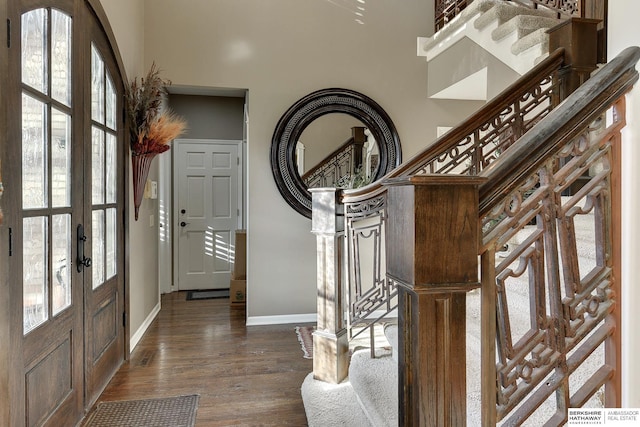 foyer entrance with baseboards, stairs, french doors, a high ceiling, and dark wood-style flooring