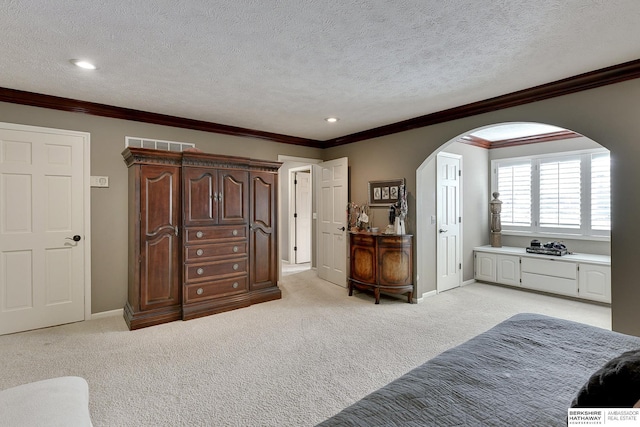 bedroom with baseboards, visible vents, arched walkways, a textured ceiling, and light carpet