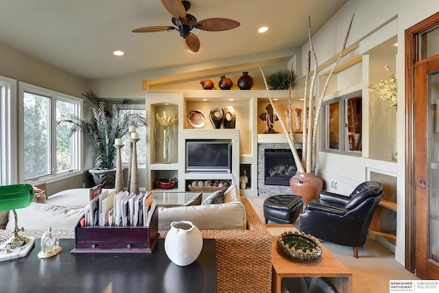 carpeted living room featuring ceiling fan, built in features, lofted ceiling, recessed lighting, and a fireplace