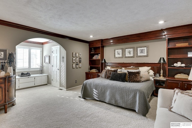 bedroom featuring a textured ceiling, arched walkways, crown molding, baseboards, and light colored carpet