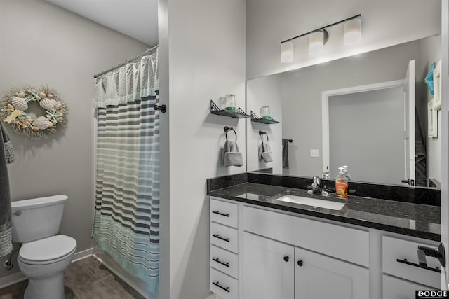 bathroom with curtained shower, baseboards, toilet, wood finished floors, and vanity