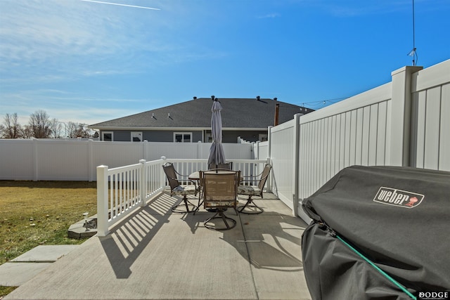 view of patio featuring grilling area, outdoor dining space, and a fenced backyard