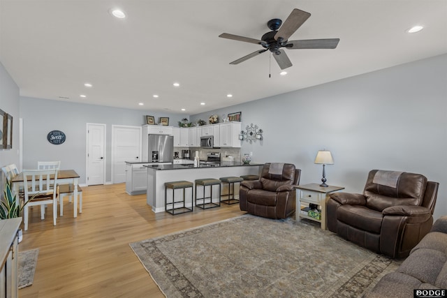 living room featuring light wood finished floors, recessed lighting, and ceiling fan