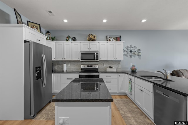 kitchen featuring a sink, tasteful backsplash, a kitchen island, and stainless steel appliances