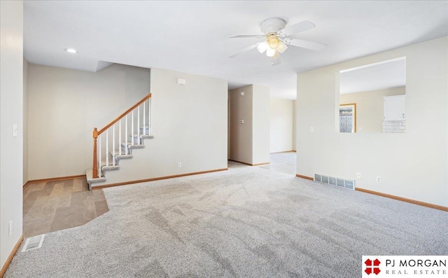 unfurnished living room with visible vents, baseboards, carpet, and stairs