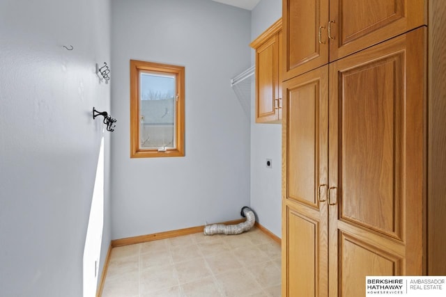 laundry area with cabinet space, baseboards, and electric dryer hookup