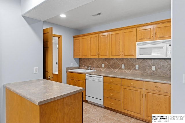 kitchen featuring visible vents, light countertops, decorative backsplash, white appliances, and a sink