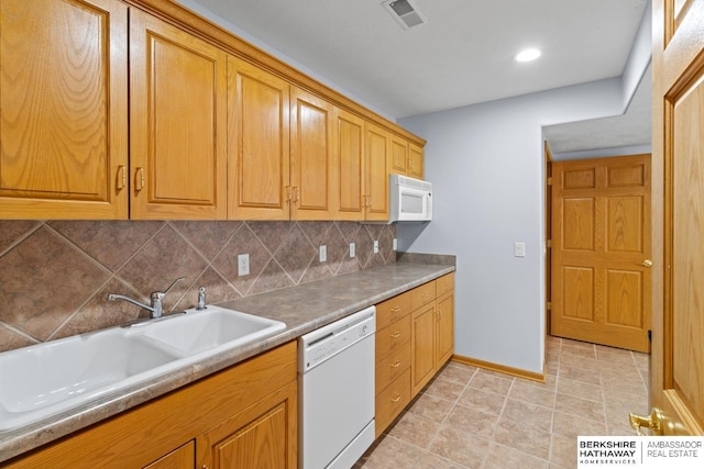 kitchen featuring visible vents, backsplash, light tile patterned floors, white appliances, and a sink