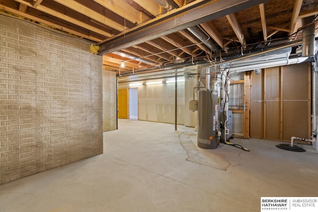 unfinished below grade area with gas water heater and brick wall