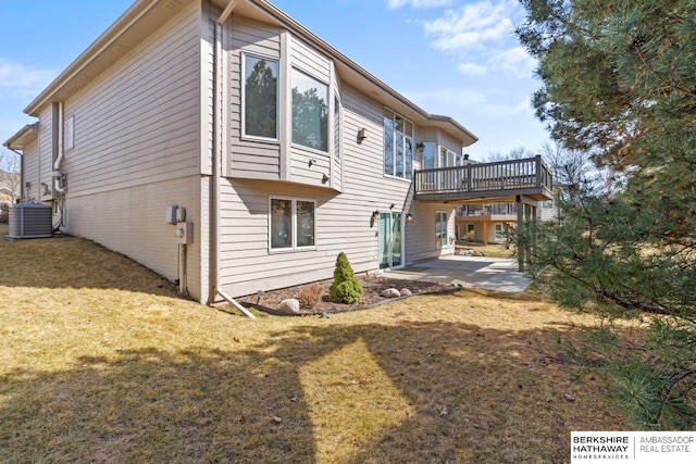 rear view of house featuring a deck, a yard, a patio area, and central AC