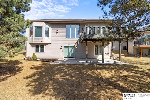 back of property featuring a wooden deck and a patio