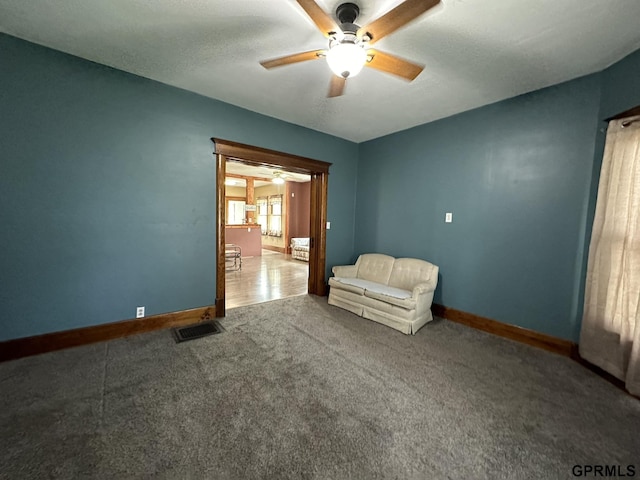 unfurnished room with visible vents, carpet flooring, baseboards, and ceiling fan