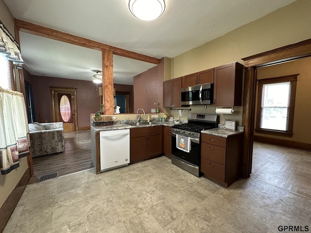 kitchen featuring visible vents, stainless steel appliances, baseboards, and a sink