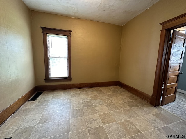 spare room featuring visible vents and baseboards