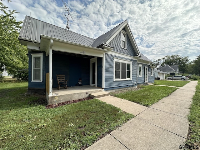 bungalow with metal roof and a front yard