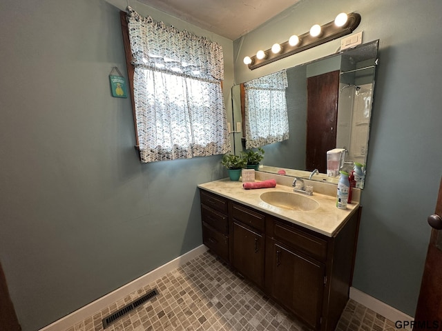 bathroom featuring vanity, baseboards, and visible vents