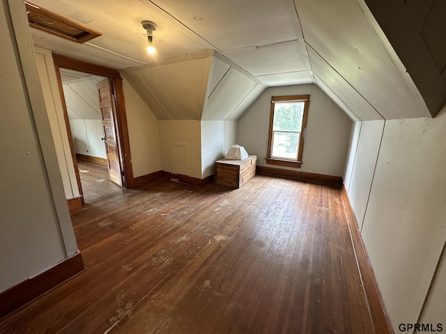 additional living space featuring hardwood / wood-style floors, vaulted ceiling, and baseboards