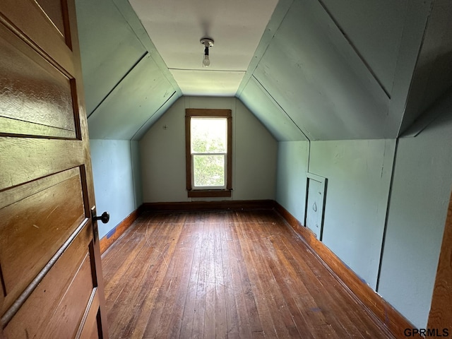 additional living space featuring vaulted ceiling, baseboards, and hardwood / wood-style floors