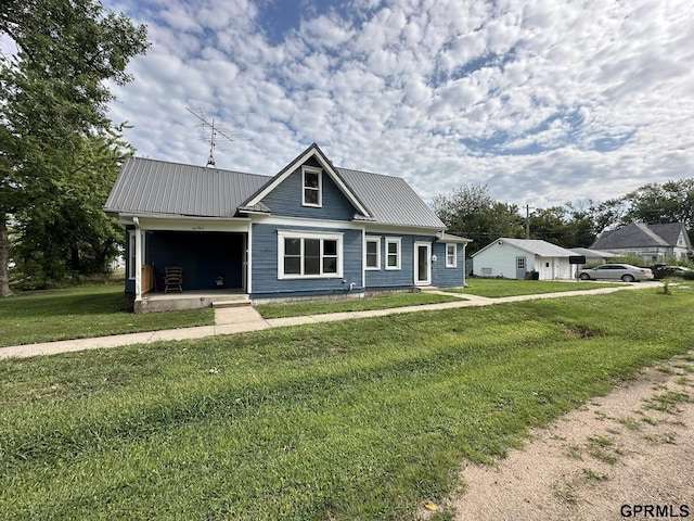 view of front of house featuring a front lawn, a garage, and metal roof