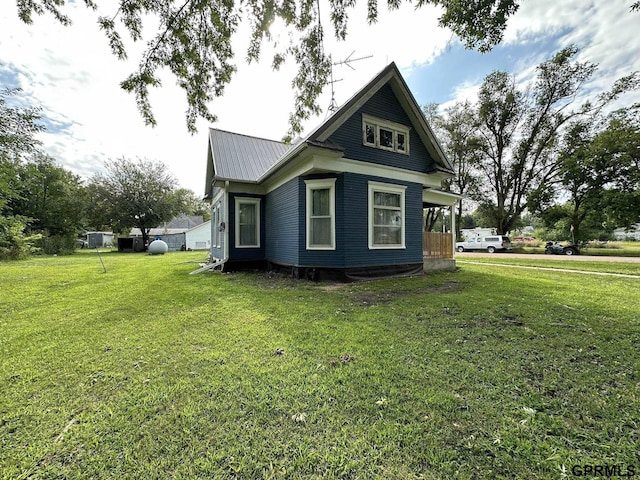 view of property exterior with metal roof and a yard