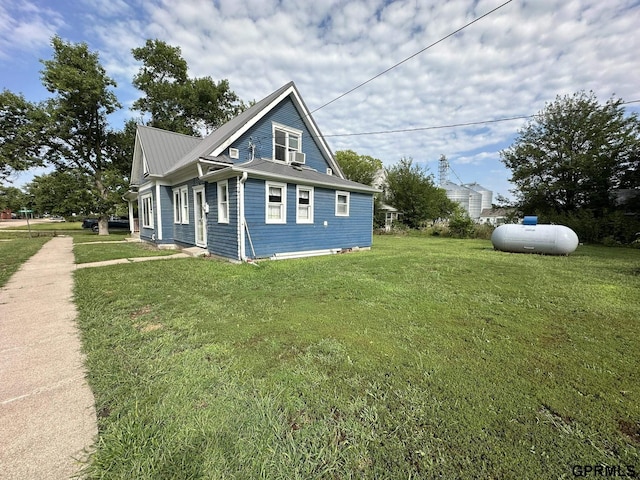 view of side of property with a lawn and metal roof