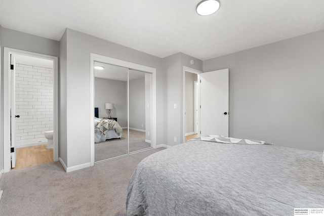 bedroom with a closet, baseboards, carpet, and connected bathroom