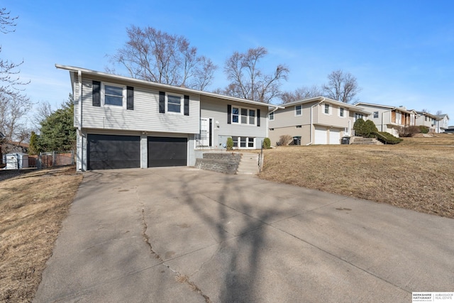 split foyer home with concrete driveway and a garage