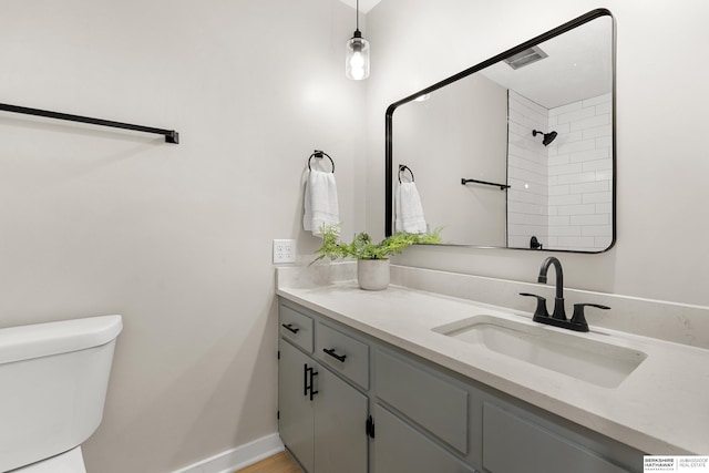 full bathroom with visible vents, baseboards, toilet, vanity, and a shower