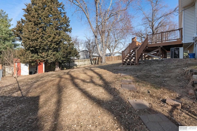 view of yard with stairs, a deck, and fence