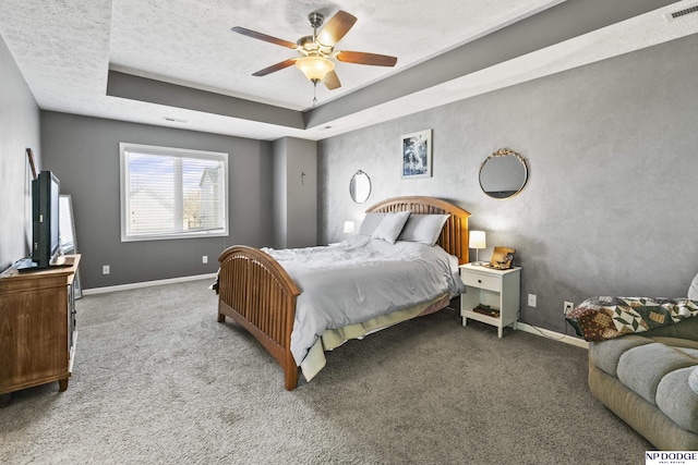 bedroom featuring a raised ceiling, visible vents, baseboards, and carpet floors