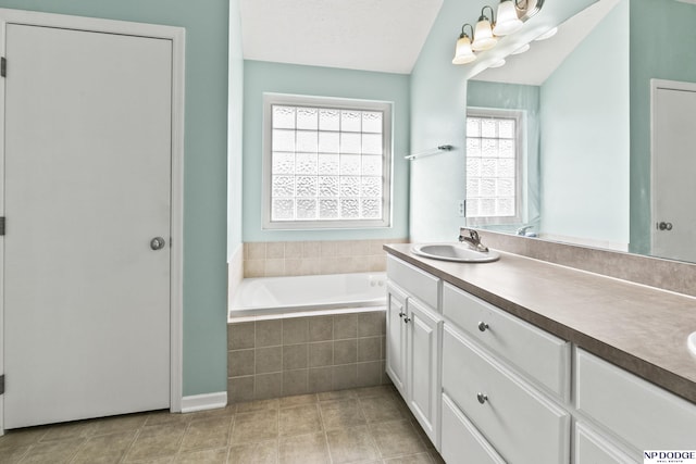 full bathroom featuring double vanity, a sink, tile patterned flooring, a textured ceiling, and a garden tub