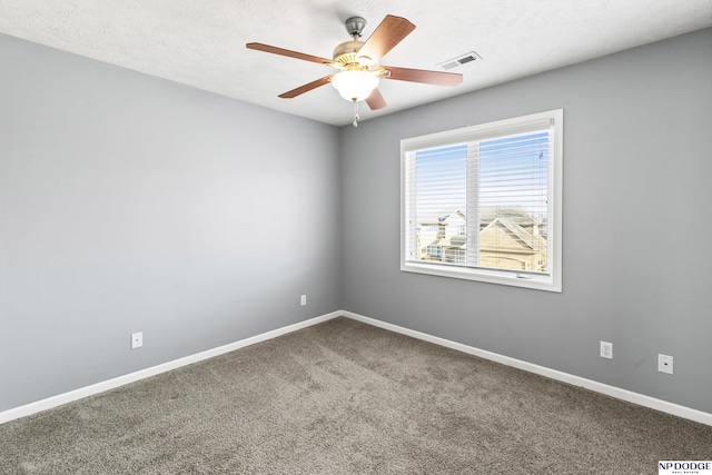 carpeted empty room featuring visible vents, baseboards, a textured ceiling, and a ceiling fan