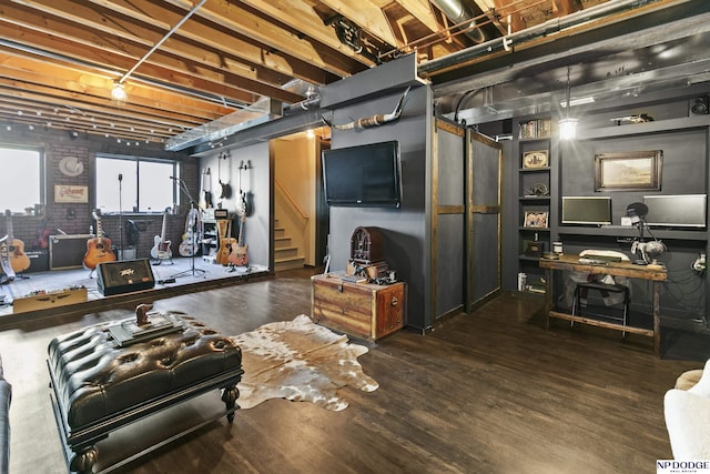 interior space with stairway, brick wall, and wood finished floors