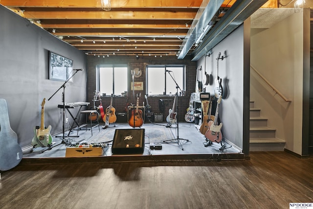 interior space with stairway, baseboards, wood finished floors, and brick wall