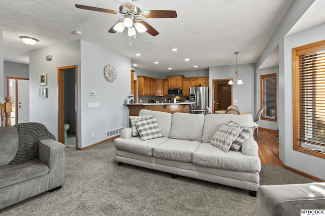 living area featuring visible vents, a ceiling fan, a textured ceiling, recessed lighting, and baseboards