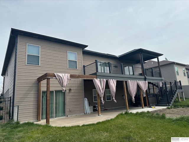 rear view of property featuring stairway, a patio area, a lawn, and a wooden deck