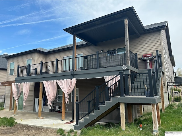 rear view of house with a deck, stairs, and a patio area