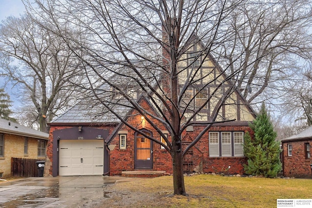 view of front of house with stucco siding, concrete driveway, an attached garage, a front yard, and brick siding