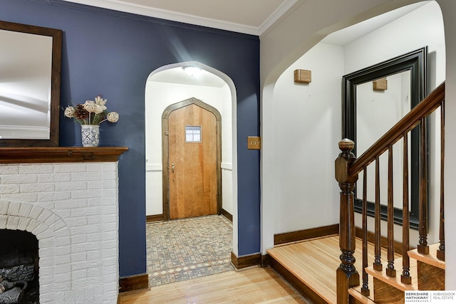 entrance foyer with stairway, baseboards, wood finished floors, and crown molding