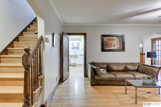 living area featuring visible vents, wood finished floors, stairway, arched walkways, and crown molding