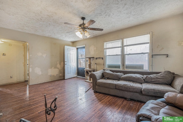 living area featuring hardwood / wood-style floors, ceiling fan, and a textured ceiling