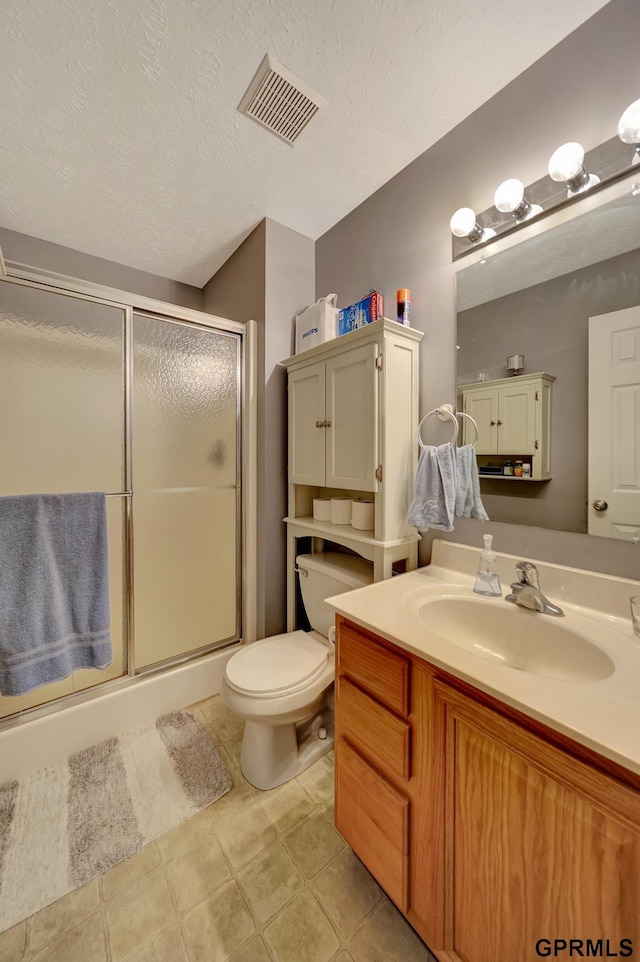 full bath featuring toilet, visible vents, a stall shower, and a textured ceiling