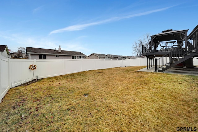 view of yard with a gazebo, stairway, and a fenced backyard