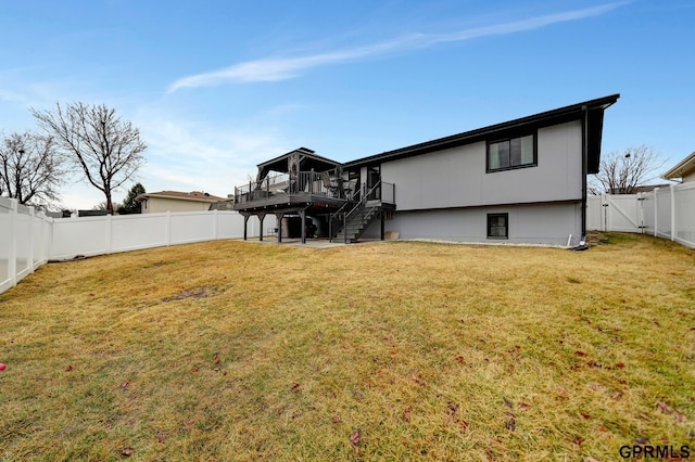 rear view of property featuring a yard, a wooden deck, a fenced backyard, and stairway