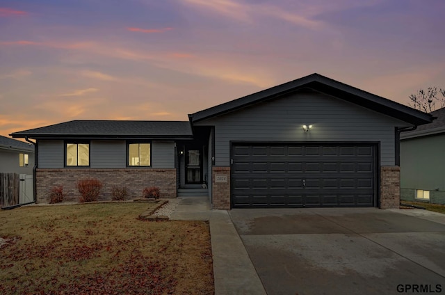 view of front of home with an attached garage, fence, brick siding, and driveway