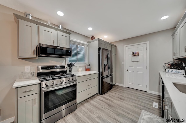 kitchen with recessed lighting, light wood-type flooring, appliances with stainless steel finishes, and light countertops